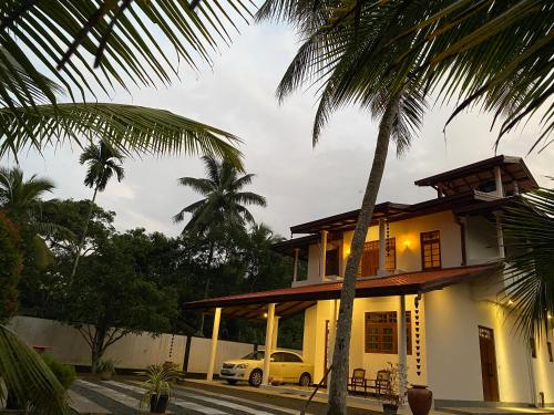 a house with a car parked in front of it at Coco Bay Villa in Galle