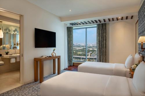 a hotel room with two beds and a large window at The H Dubai in Dubai