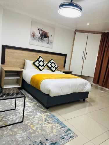 a bedroom with a large bed with yellow and black pillows at Legugu Bed and Breakfast in Nongoma