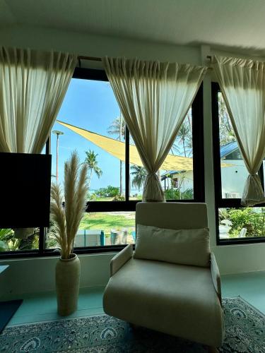 a living room with a couch and a large window at 2BD beachfront house in Chaloclum in Mae Haad