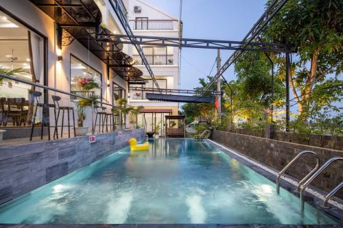 a swimming pool in the middle of a building at 1 Stop ViVi An Bang Beach Hoi An Hotel in Hoi An