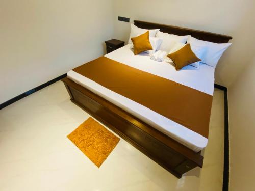 a bedroom with a large bed with yellow pillows at Coco Bay Villa in Galle