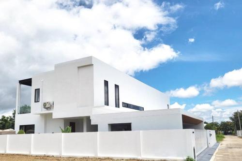 a white house with a fence in front of it at Poon Pool villa near Ruamchok Boxing private pool etc in Chiang Mai