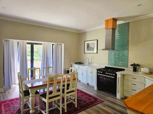 a kitchen with a wooden table and a dining room at 2 Annie's Place Rawdons Country Estate in Nottingham Road