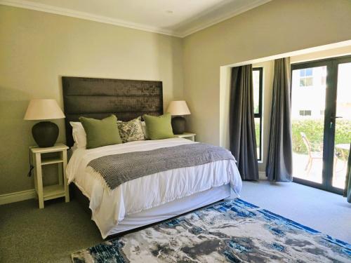 a bedroom with a bed and a large window at 2 Annie's Place Rawdons Country Estate in Nottingham Road