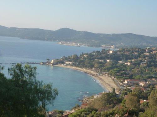 - une vue sur une plage avec des arbres et des maisons dans l'établissement LE LAVANDOU ST CLAIR STUDIO 300 m de la PLAGE parking, au Lavandou
