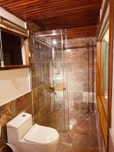 a bathroom with a toilet and a glass shower at Tam Coc Golden Fields in Ninh Binh