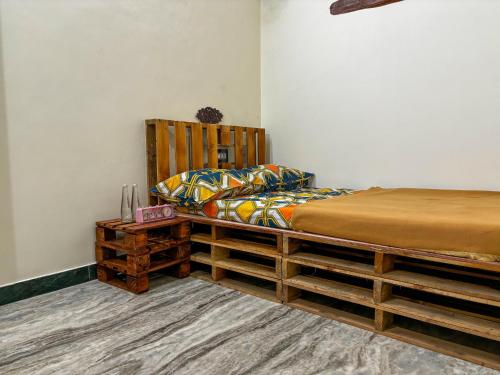een slaapkamer met een bed en een houten hoofdeinde bij Villa Seasoul in Pondicherry