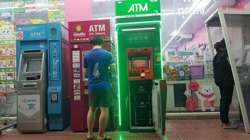 a man is standing in front of an atm machine at Love Seeker House in Ko Lanta