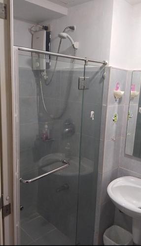 une douche avec une porte en verre dans une salle de bain dans l'établissement Joie Selene, à Manille