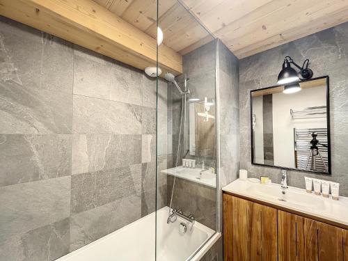 une salle de bain avec une baignoire, un lavabo et un miroir dans l'établissement Jardin Darnica - appartement - 6pers-proche piste, aux Gets
