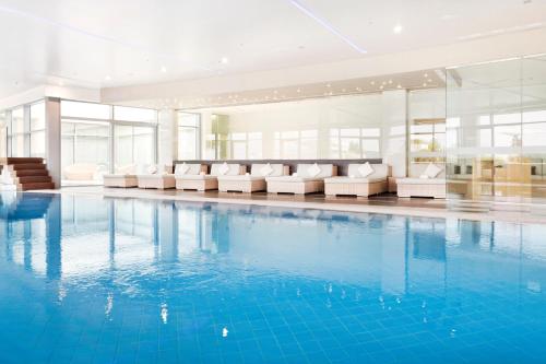 a large swimming pool with couches and a pool at Sun Gardens Dubrovnik in Dubrovnik