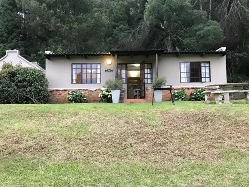 a house with a picnic table in front of it at The Retreat Country Lodge in Romelcoh