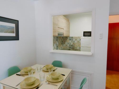 a dining room with a white table and a mirror at Apartamentos Eldorado in Lloret de Mar