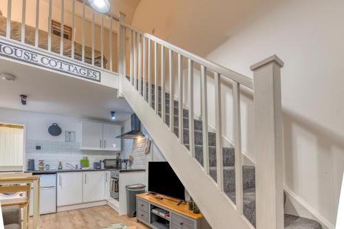 a kitchen with a staircase in a house conversions at Butland Cottage in Pembroke