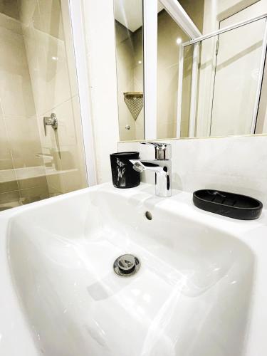 a white sink in a bathroom with a mirror at Glorystar The Millennial Umhlanga in Durban