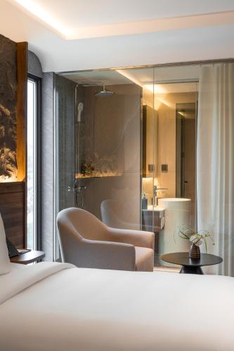 a hotel room with a bed and a bathroom at Kin Hotel Thai Van Lung in Ho Chi Minh City