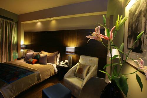 una camera d'albergo con letto e sedia di ​juSTa Gurgaon a Gurgaon