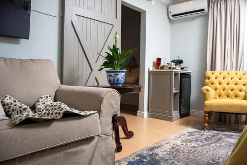 a living room with a couch and a chair at 53A Luxury Bed & Breakfast in Gaborone