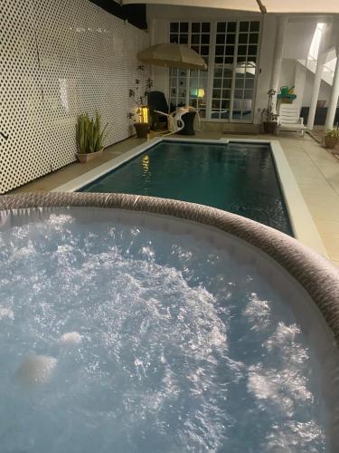 a large swimming pool with a hot tub at HCEAS villa is 5 min fr. airport & to the beaches in Bon Accord