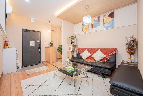 a living room with a black couch and a glass table at Jone叙園商店街近隣駅徒步5分 新宿12分 in Tokyo