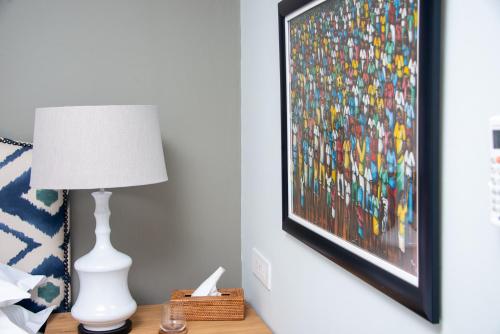 a lamp on a table next to a painting on a wall at 53A Luxury Bed & Breakfast in Gaborone