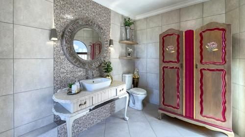 モッセル・ベイにあるVillla Loreaの洗面台、鏡、トイレ付きのバスルーム