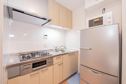 a kitchen with a stainless steel refrigerator and a sink at Jone叙園商店街近隣駅徒步5分 新宿12分 in Tokyo