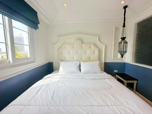 a large white bed in a blue and white bedroom at Jomtien Beach, Pattaya - Seven Seas Côte d'Azur in Na Jomtien