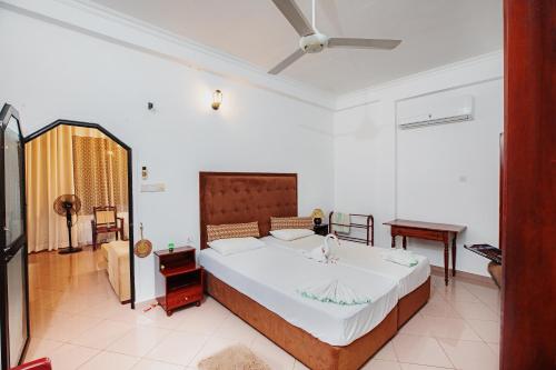 a bedroom with a large bed in a room at Sagarika Beach Hotel in Moragalla