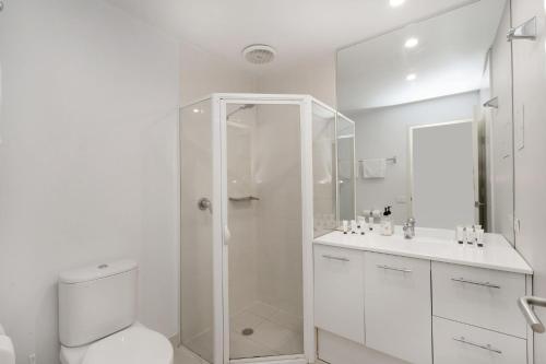 a white bathroom with a shower and a toilet at Sleek 2-Bed Apartment in Vibrant Kingston in Kingston 