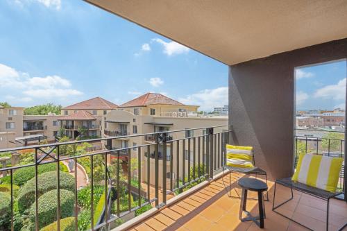 a balcony with a chair and a view at Sleek 2-Bed Apartment in Vibrant Kingston in Kingston 