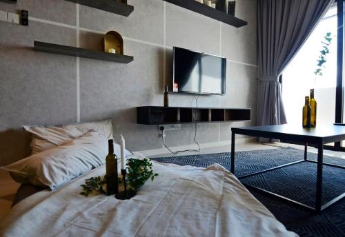Stylish & Cozy Stay at Suasana Suites JB 11 في جوهور باهرو: غرفة بسرير وطاولة وتلفزيون