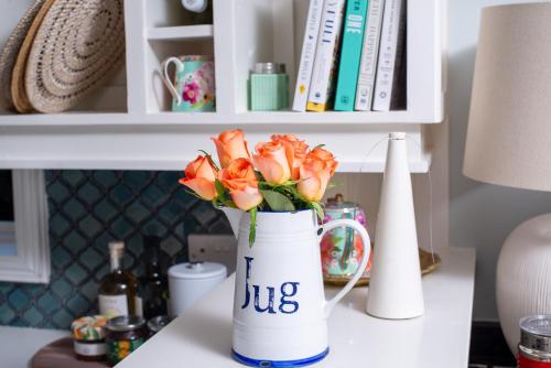 a vase filled with orange roses sitting on a table at 53A Luxury Bed & Breakfast in Gaborone