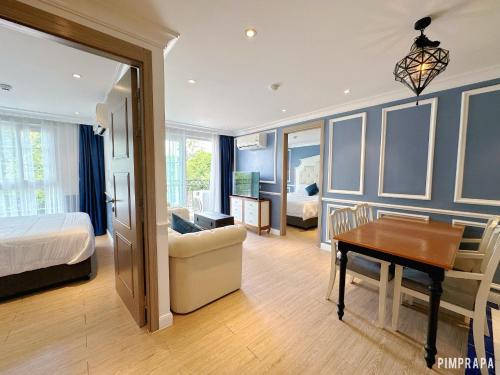 a bedroom with a bed and a desk and a table at Jomtien Beach, Pattaya - Seven Seas Côte d'Azur in Na Jomtien