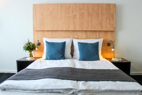 a bedroom with a large bed with blue pillows at Good Morning + Bad Oldesloe in Bad Oldesloe