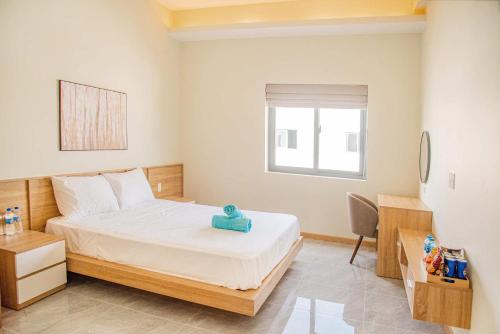 a small bedroom with a bed and a desk at The Vista Châu Đốc Hotel in Chau Doc