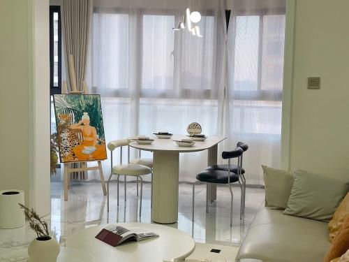 a living room with a table and chairs and a couch at Island Flower Coconut 花椰椰民宿 in Haikou