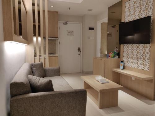 a living room with a couch and a table at Astara Hotel Balikpapan in Balikpapan