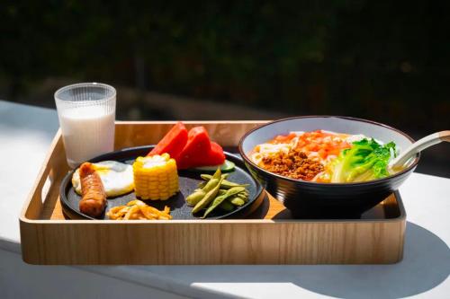 a tray of food with a bowl of rice and vegetables at Miyue Shenzhen Blue and White Holy Island Cliff Pool Hotel in Shenzhen