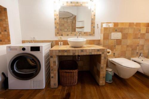 a bathroom with a washing machine and a sink at Hiša Linhart Apartment in Radovljica