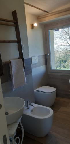 a bathroom with a sink and a toilet and a window at CASCINA BINELLO appartamenti A & B in Belvedere Langhe