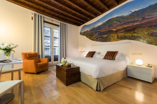 a bedroom with a bed and a painting on the wall at Gar Anat Hotel Boutique in Granada