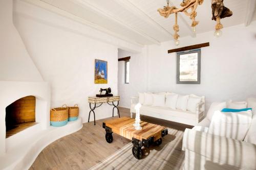 a living room with a white couch and a fireplace at Axiotheaton Villas in Pefki Rhodes