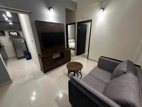 a living room with a couch and a television at Trinetra Homes 61 in Bengaluru