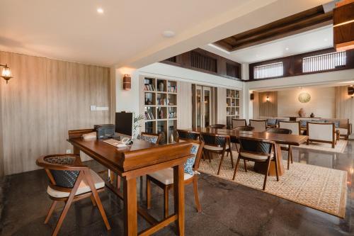 a dining room with wooden tables and chairs at Ramayana Suites and Resort in Kuta