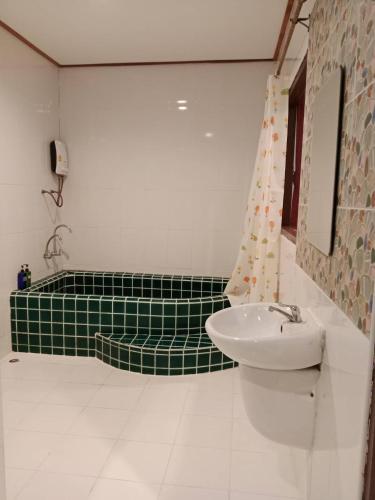 a bathroom with a sink and a green and white at Chill Chill resort in Pran Buri