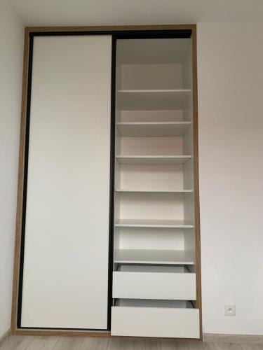 a closet with white shelves and a mirror at Aura Home in Grywałd