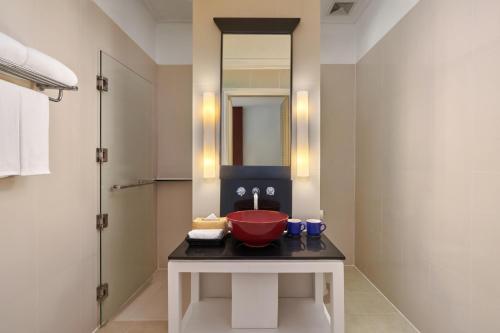 a bathroom with a red sink and a mirror at Homm Souvannaphoum Luang Prabang, part of Banyan Group in Luang Prabang