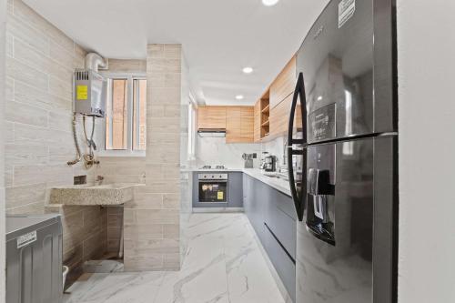 a kitchen with a refrigerator and a sink at Spacious Apartment with 2 Bedrooms in CDMX in Mexico City